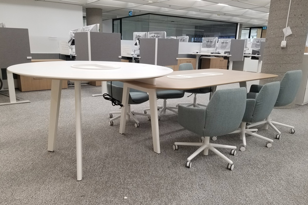 Standing table connected to a regular table with several chairs