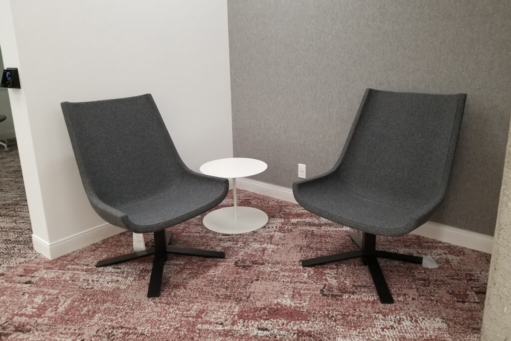 Two chairs in a corner with a small table
